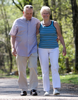 Couple walking along wooded trail Couple walking along wooded trail