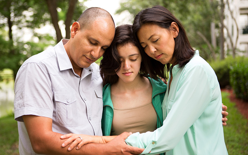 Three people in prayer Three people in prayer
