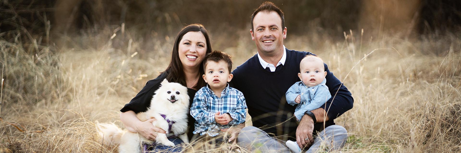 Family of Four Sitting in Field