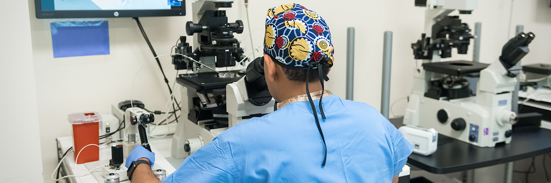 Male Researcher Looking Through Microscope