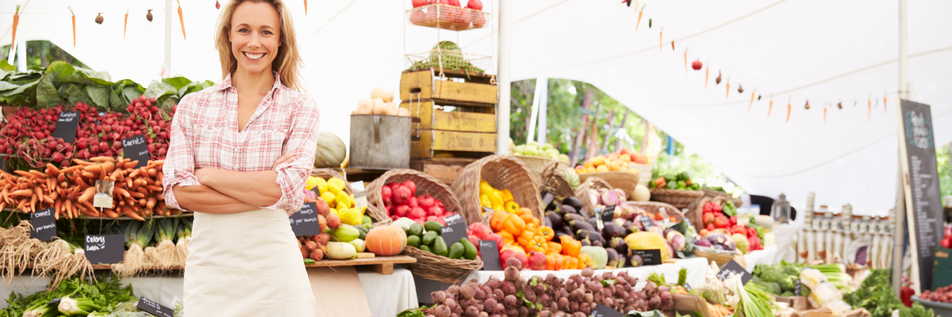 Woman in Apron Smiling at a Farmer's Market