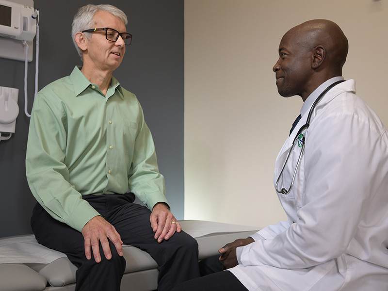 Clinician discussing care with a patient in an exam room