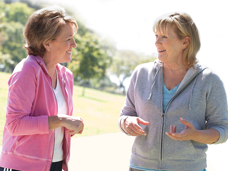 Two people talking together outdoors in a park
