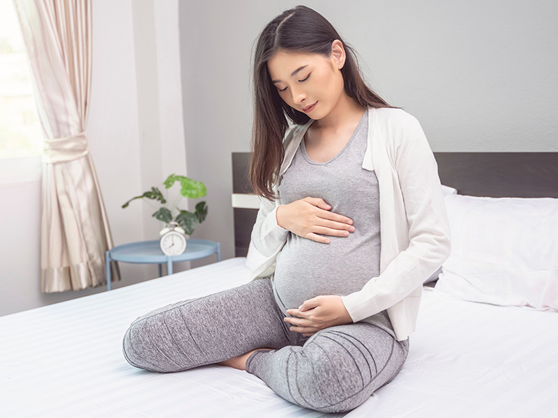Pregnant woman holding stomach
