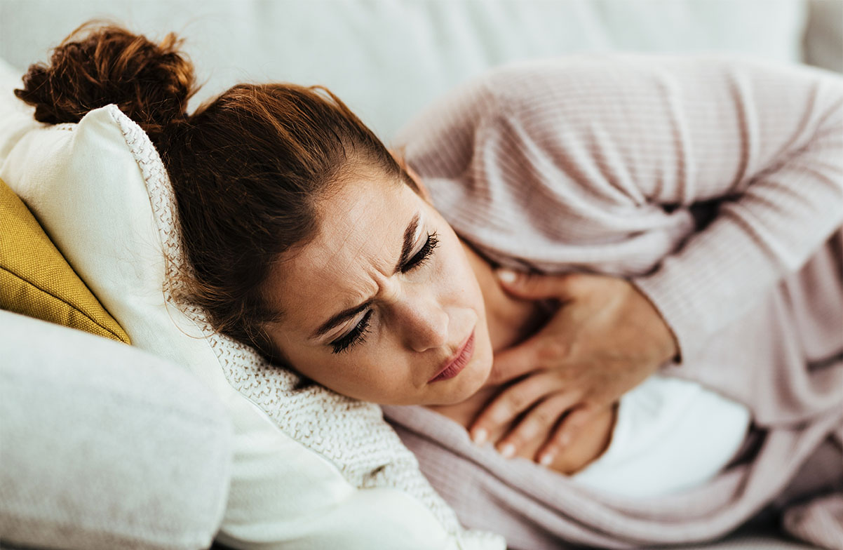 Woman on couch touching chest