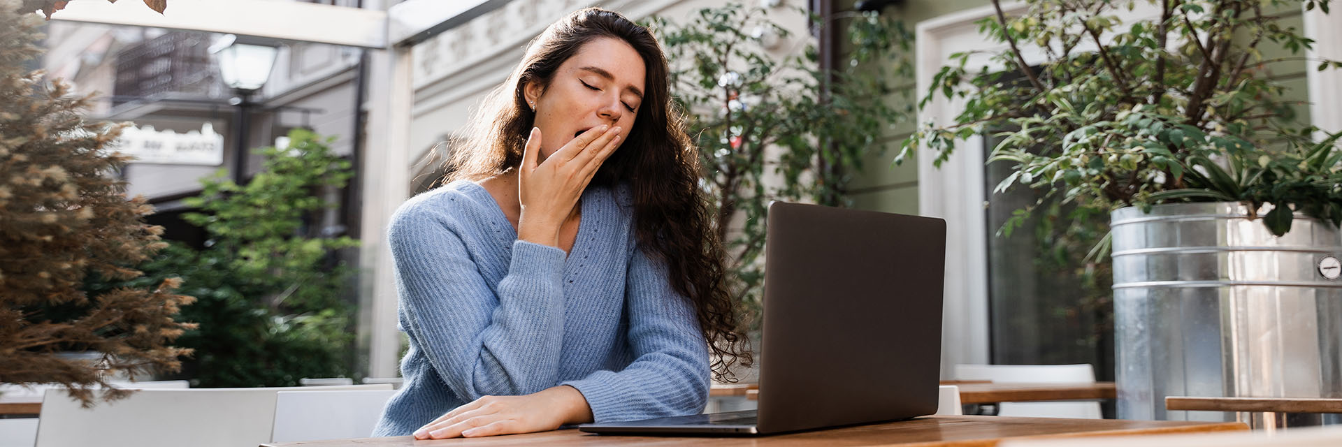 Tired woman working on her laptop outdoors