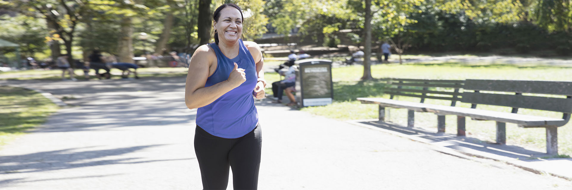 Woman jogging in the park in a blue tank