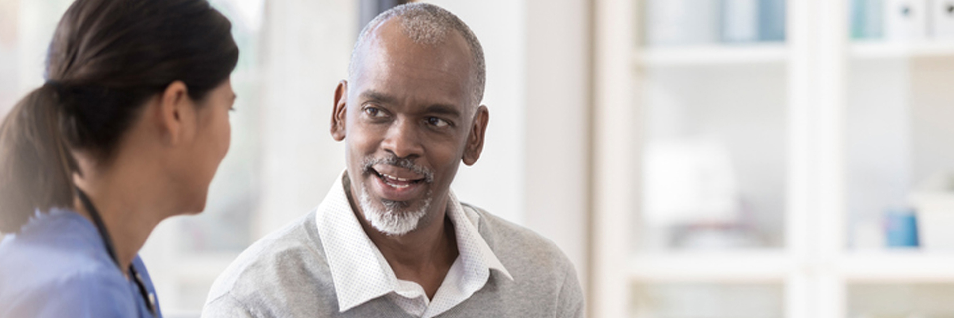 Man talking to nurse with clipboard