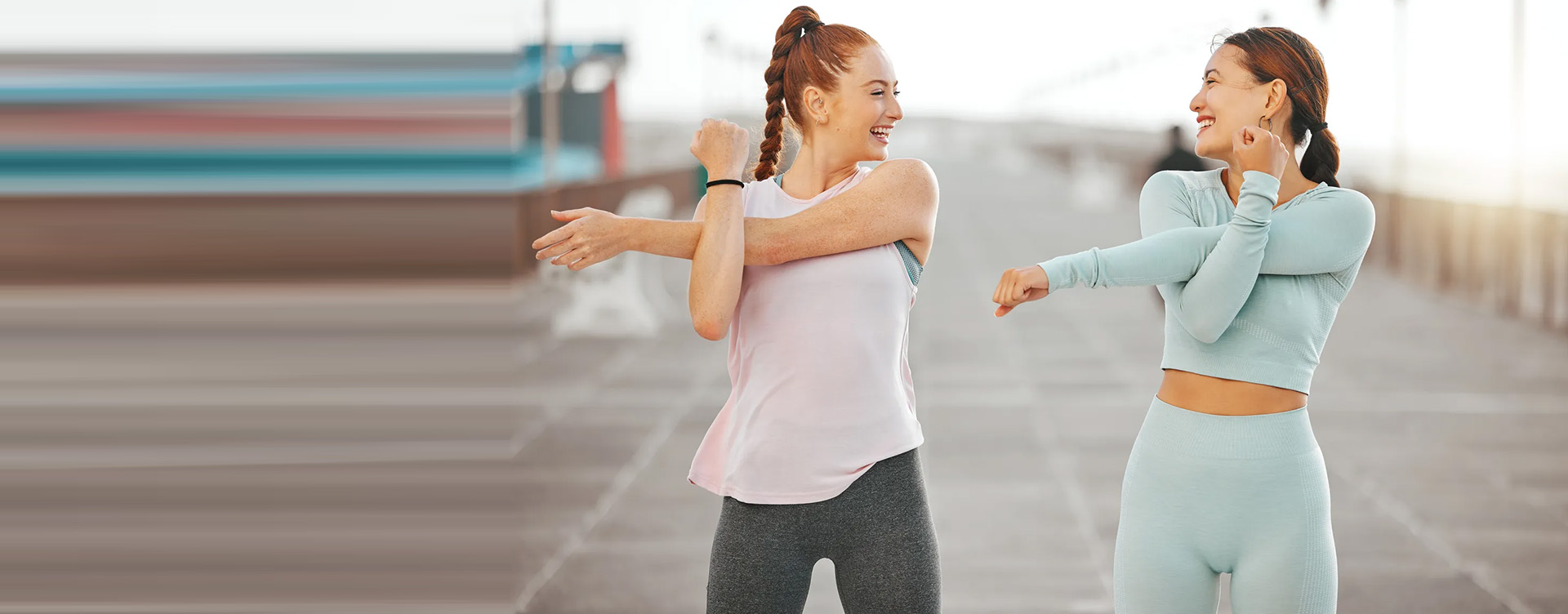 Two individuals stretching outdoors