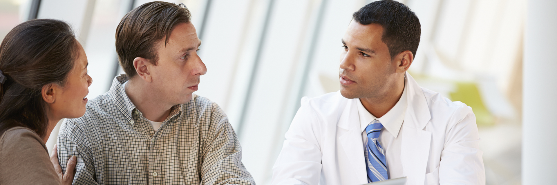 Couple speaking with a male doctor