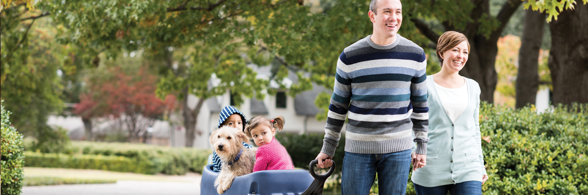 Family walking outdoors pulling kids in wagon